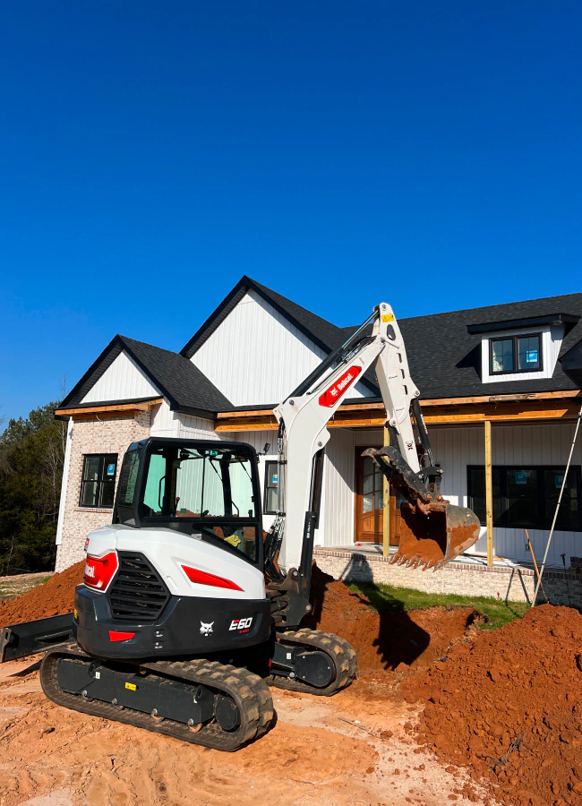 small excavator in front of residential house